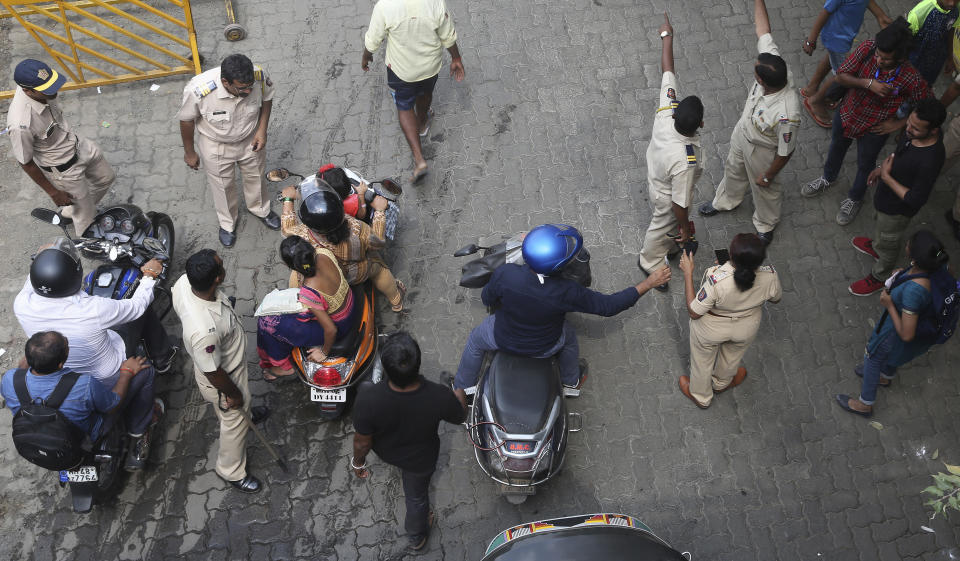 Indian police check the identity of commuters at Aarey Colony, Mumbai, India, Monday, Oct, 7, 2019. India's Supreme Court has ordered the government of the Indian state of Maharashtra to stop tree-felling after protesters swarmed the area. The court order on Monday stalls tree-cutting at least until another hearing October 21. (AP Photo/Rafiq Maqbool)