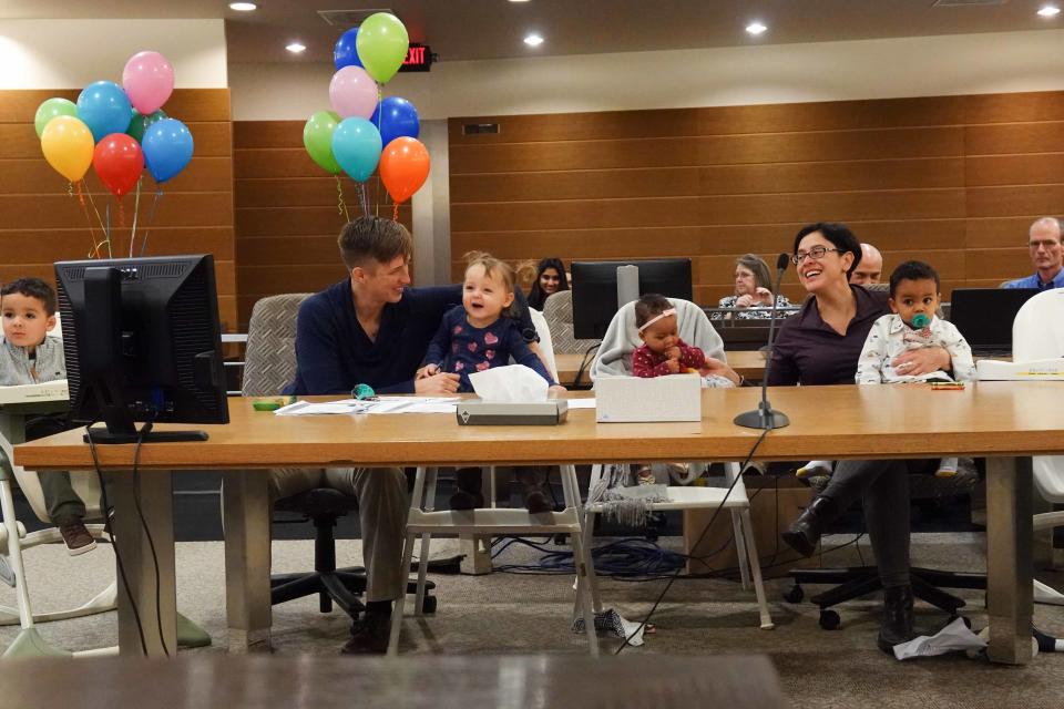 Dr. Erin Meyer and her wife and Dr. Sandra Medinilla sit with their four adopted children during an adoption ceremony for their fourth child, 6-month-old Sydney.