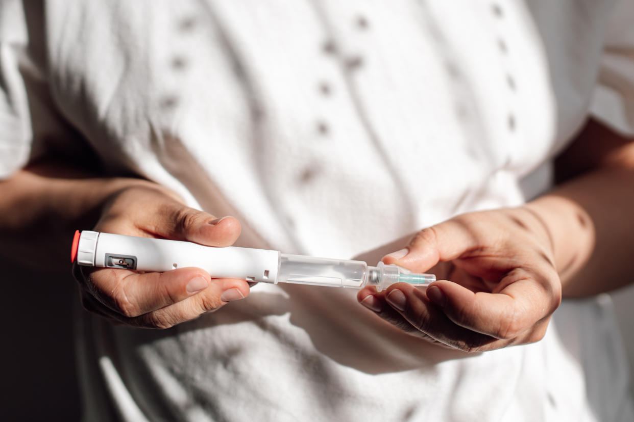 A person holds an injectable weight loss drug.