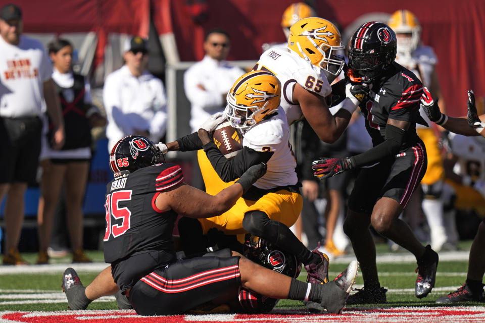 Utah defensive tackle Aliki Vimahi (95) tackles Arizona State wide receiver Elijhah Badger (2) during the first half of an NCAA college football game Saturday, Nov. 4, 2023, in Salt Lake City. (AP Photo/Rick Bowmer)