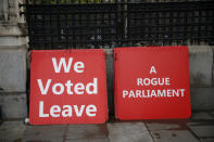 Placards placed by Brexit supporters lean against a wall outside the Houses of Parliament in London, Thursday, Sept. 26, 2019. British Prime Minister Boris Johnson faced a backlash from furious lawmakers Thursday over his use of charged and confrontational language in Parliament about opponents of his Brexit plan. (AP Photo/Matt Dunham)