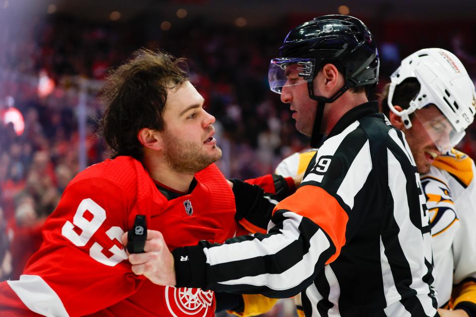 Referee Ian Walsh (29) separates Detroit Red Wings right wing Alex DeBrincat (93) and Nashville Predators defenseman Roman Josi (59) during the second period of the game between the Nashville Predators and the Detroit Red Wings at Little Caesars Arena in Detroit on Friday, Dec. 29, 2023.