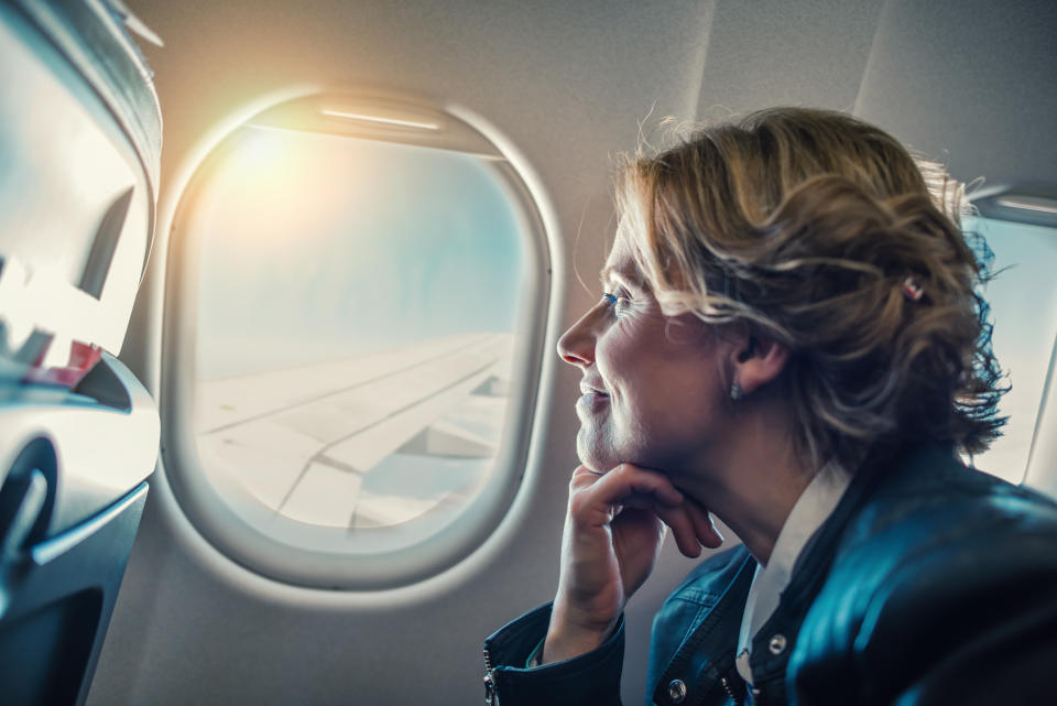 Close-up of a passenger looking out of a plane window