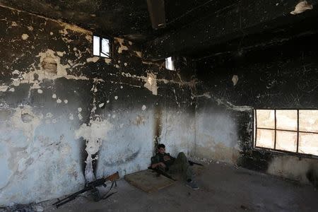 A rebel fighter rests inside a damaged room in Marea city, northern Aleppo province, Syria October 21, 2016. REUTERS/Khalil Ashawi