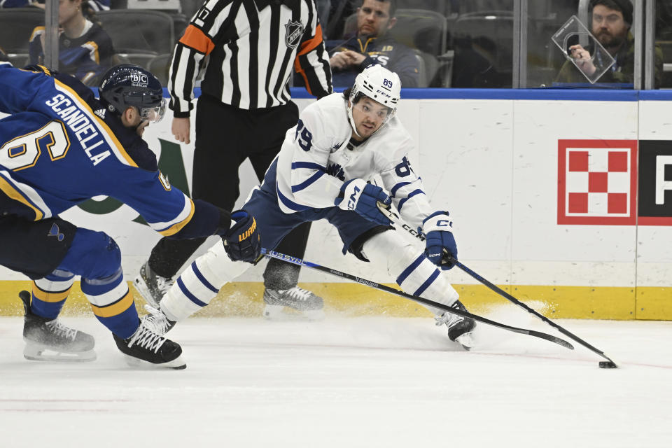 Toronto Maple Leafs' Nicholas Robertson (89) fights for the puck against St. Louis Blues' Marco Scandella (6) during the third period of an NHL hockey game Monday, Feb. 19, 2024, in St. Louis. (AP Photo/Michael Thomas)