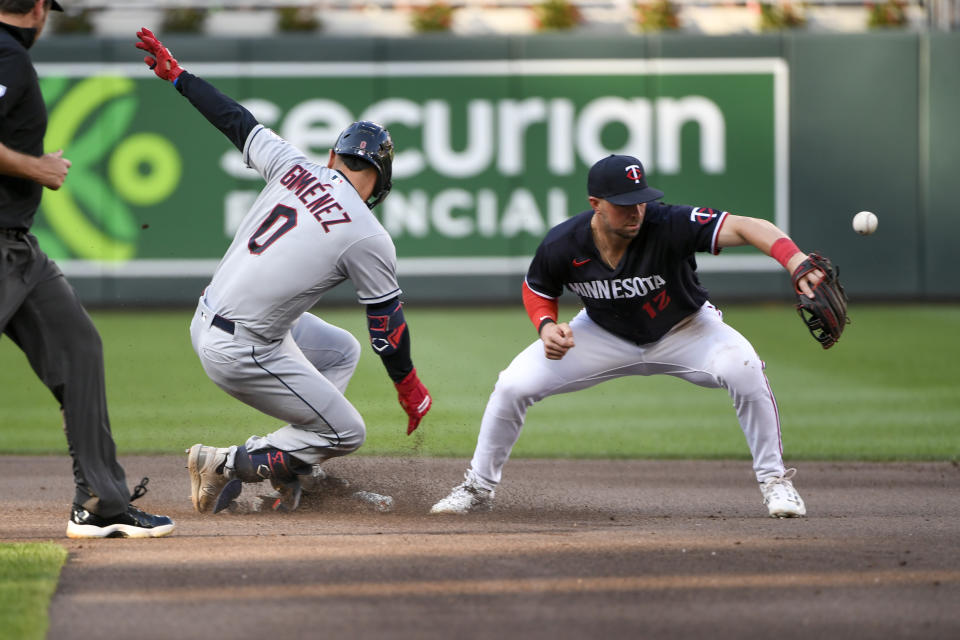 Cleveland Guardians' Andres Gimenez (0) is safe at second after hitting a double before Minnesota Twins shortstop Kyle Farmer (12) can make a tag during the fourth inning of a baseball game, Saturday, June 3, 2023, in Minneapolis. (AP Photo/Craig Lassig)