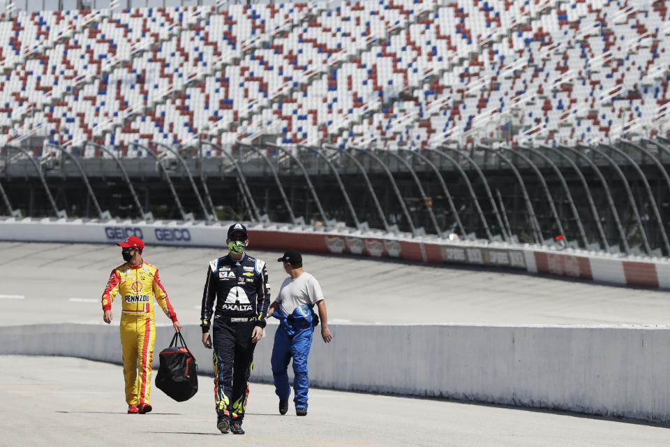 Drivers walk to their cars for the start of the NASCAR Cup Series auto race Sunday, May 17, 2020, in Darlington, S.C. (AP Photo/Brynn Anderson)