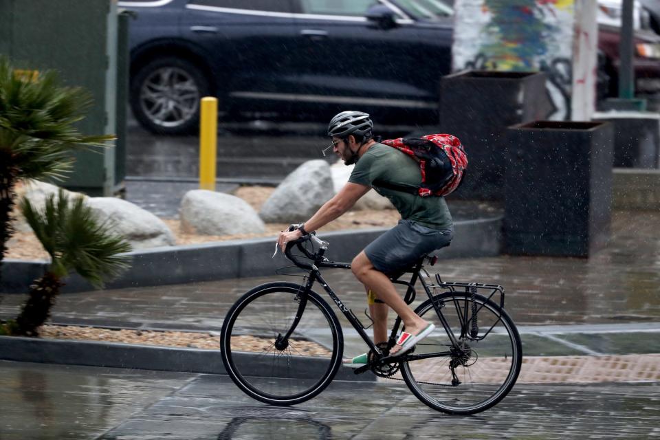 A bicyclist rides through rain in Palm Springs on Jan. 22. The Coachella Valley is expected to see more rain on Thursday.