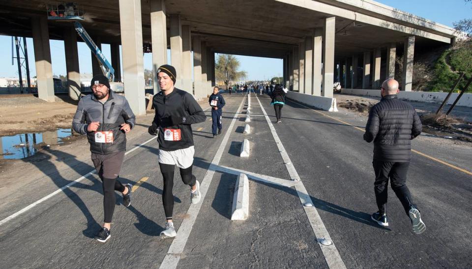 Runners head out and return on 9th Street during the Modesto Marathon in Modesto, Calif., Sunday, March 26, 2023.