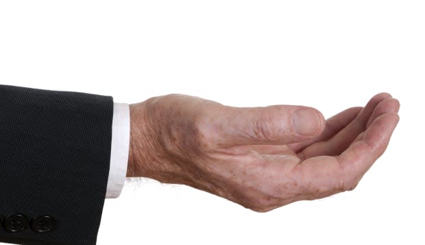 Senior businessman hand outstretched - asking or offering.