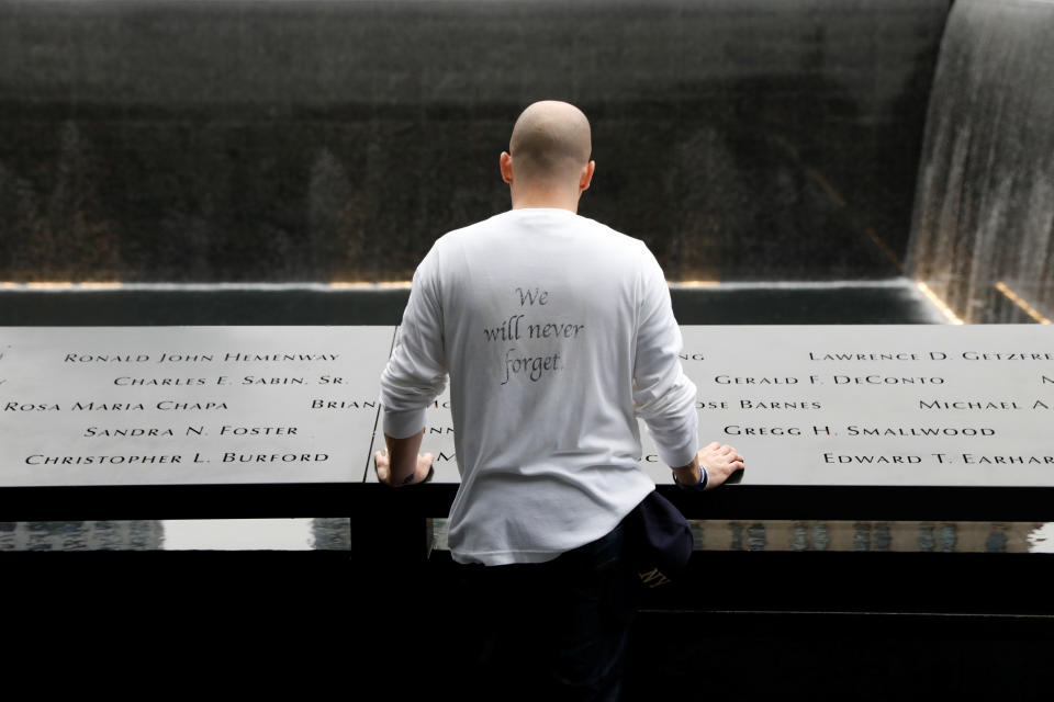 <p>A guest visits the south reflecting pool as he lays his hands on the names of victims during ceremonies marking the 17th anniversary of the September 11, 2001 attacks on the World Trade Center, at the National 9/11 Memorial and Museum in New York, Sept.11, 2018. (Photo: Brendan McDermid/Reuters) </p>