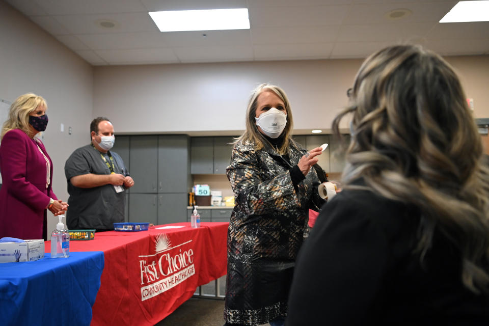 First lady Jill Biden watches as New Mexico Gov. Michelle Lujan Grisham gives a sticker to a woman who had just received a COVID-19 vaccination during a visit to First Choice Community Healthcare - South Valley Medical Center in Albuquerque, N.M., Tuesday, April 21, 2021. (Mandel Ngan/Pool via AP)