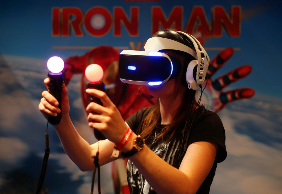 A gamer plays on a Playstation VR with virtual reality goggles and two controllers that look like regular bulbs during the first day of Europe's leading digital games fair Gamescom, which showcases the latest trends of the computer gaming scene in Cologne, Germany, August 21, 2019. REUTERS/Wolfgang Rattay - RC14DF7A0E40