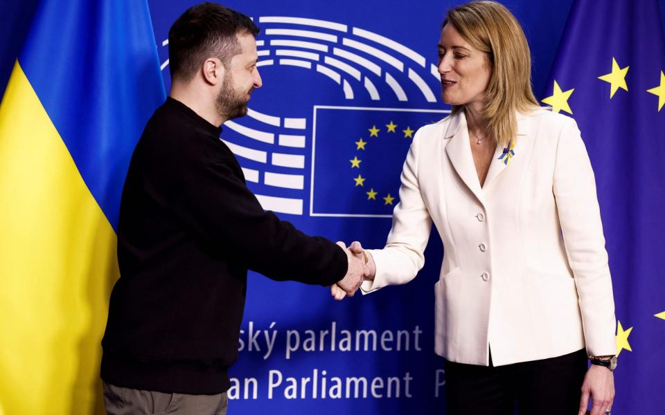 Ukraine's president Volodymyr Zelensky (L) shakes hands with European Parliament President Roberta Metsola as he arrives for a summit at EU parliament in Brussels - KENZO TRIBOUILLARD/AFP