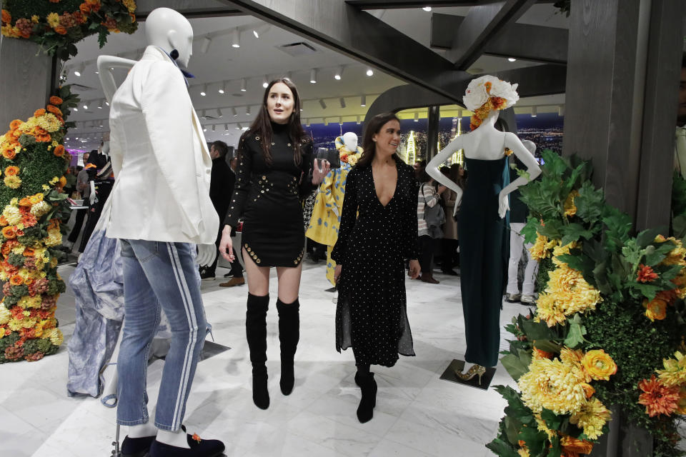 FILE - In this March 14, 2019, file photo women shop at Neiman Marcus during the opening night of The Shops & Restaurants at Hudson Yards in New York. Luxury department stores like Neiman Marcus and Saks Fifth Avenue once ruled among the affluent set. Now, they’re fighting a tough battle to lure younger shoppers faced with a lot more shopping choices, including second-hand retailers and fashion rental companies. (AP Photo/Mark Lennihan, File)