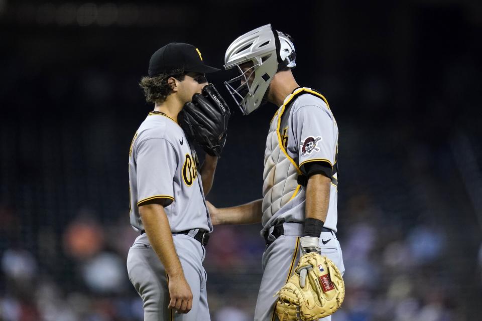 Pittsburgh Pirates starting pitcher Max Kranick, left, talks with catcher Jacob Stallings during the fourth inning of the team's baseball game against the Arizona Diamondbacks, Wednesday, July 21, 2021, in Phoenix. (AP Photo/Ross D. Franklin)