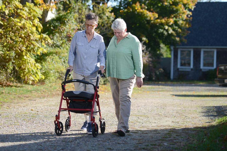 Caregiver Dawn Ericson-Taylor, right, heads out for a morning walk with Patty Ericson-Taylor in Hyannis. During the pandemic, tired from overwork at an assisted living facility, Patty suffered a hemorrhagic stroke, thrusting Dawn into the role of care giver. Dawn can't afford private care and her  income doesn't qualify her for MassHealth. State Sen. Jo Comerford has filed legislation to expand the definition of family members eligible to be reimbursed through MassHealth.