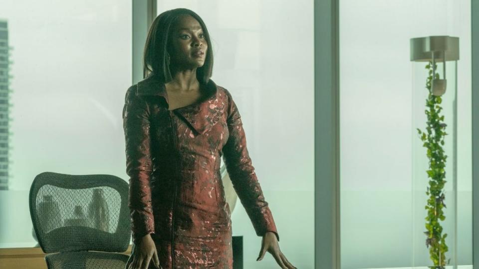 Yetide Badaki as Neera in Strange New Worlds stands at a table wearing a burgundy dress