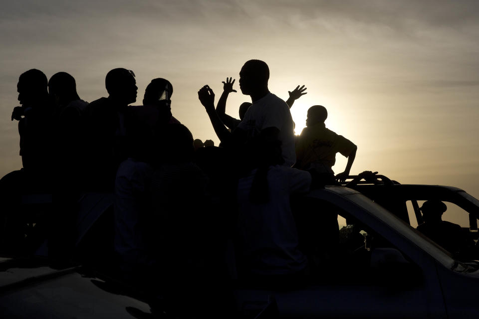 People cheer as Gambian President Adama Barrow rides his motorcade through crowds of hundreds of thousands after arriving at Banjul airport in Gambia, Thursday Jan. 26, 2017, after flying in from Dakar, Senegal. Gambia's new president has finally arrived in the country, a week after taking the oath of office abroad amid a whirlwind political crisis. Here's a look at the tumble of events that led to Adama Barrow's return — and the exile of the country's longtime leader. (AP Photo/Jerome Delay)