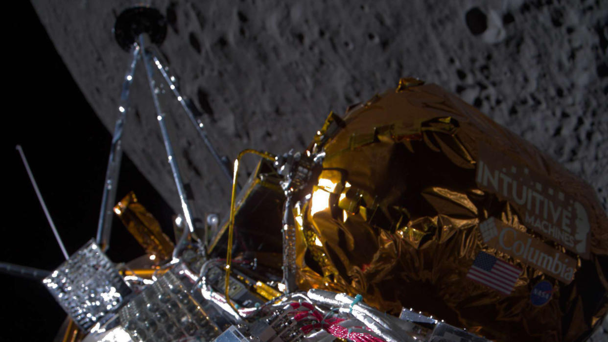  A private Intuitive Machines moon lander in lunar orbit with the moon's cratered surface below with black space in the background. 