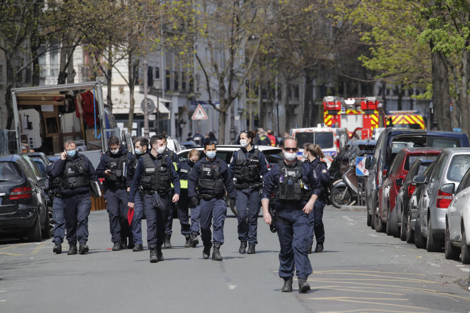 Police officers leave the scene after a shooting Monday, April 12, 2021 in Paris. A gunman has shot two people in front of a hospital in Paris and the attacker fled on a motorcycle. (AP Photo/Christophe Ena)