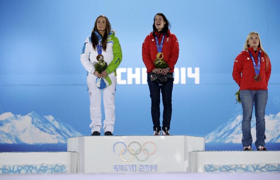 Women's downhill medalists, from left, Slovenia's Tina Maze and Switzerland's Dominique Gisin, who tied for the gold, and Switzerland's Lara Gut, who finished third for the bronze, pose with their medals at the 2014 Winter Olympics in Sochi, Russia, Wednesday, Feb. 12, 2014. (AP Photo/Morry Gash)