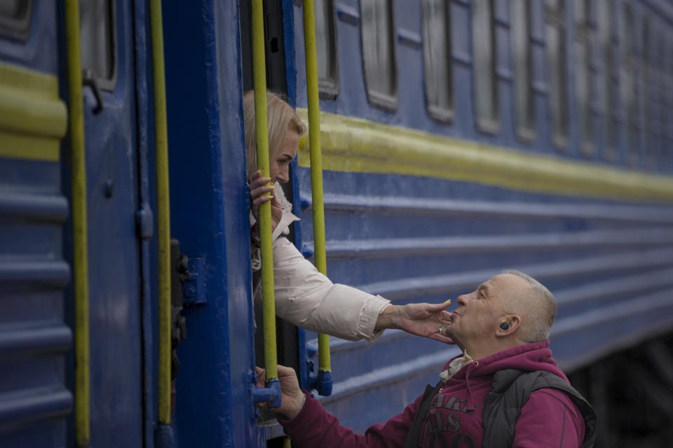 A man kisses a woman&#39;s hand as she boards a train in Kyiv on Thursday.