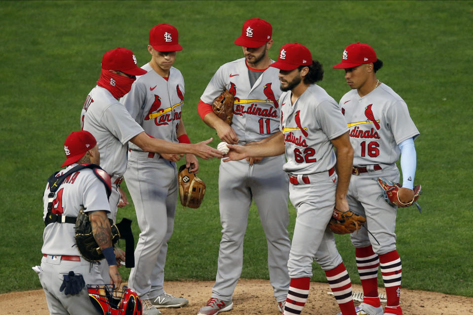 El pitcher de los Cardenales de San Luis Daniel Ponce de León entrega la pelota al manager Mike Shildt luego de dejar el encuentro ante los Mellizos de Minnesota en la quinta entrada, el miércoles 29 de julio de 2020, en Minneapolis. (AP Foto/Jim Mone)