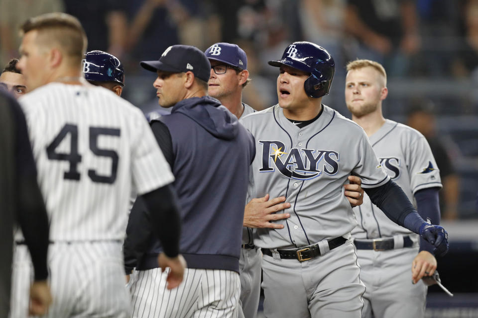 Tampa Bay Rays pitching coach Kyle Snyder, center rear, restrains Rays' Avisail Garcia, second from right, as benches and bullpens cleared during a dispute between Garcia and New York Yankees starting pitcher CC Sabathia during the sixth inning of a baseball game Tuesday, July 16, 2019, in New York. Yankees manager Aaron Boone is fourth from right. (AP Photo/Kathy Willens)