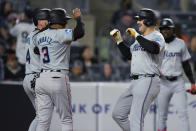 Miami Marlins' Jake Burger, right front, is greeted by teammates after hitting a three-run home run during the third inning of the team's baseball game against the New York Yankees at Yankee Stadium, Wednesday, April 10, 2024, in New York. (AP Photo/Seth Wenig)