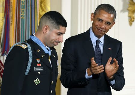 U.S. President Barack Obama applauds retired U.S. Army Captain Florent Groberg, 32, after presenting him with the Medal of Honor during a ceremony at the White House in Washington, DC November 12, 2015. REUTERS/Kevin Lamarque