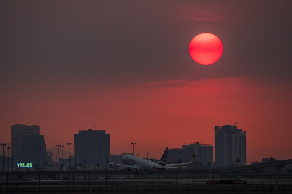 The sun sets over downtown Phoenix as it glows red from smoke from the Telegraph Fire burning east of the city on June 15, 2021. The National Weather Service in Phoenix issued an excessive heat warning for portions of south-central Arizona through the week.