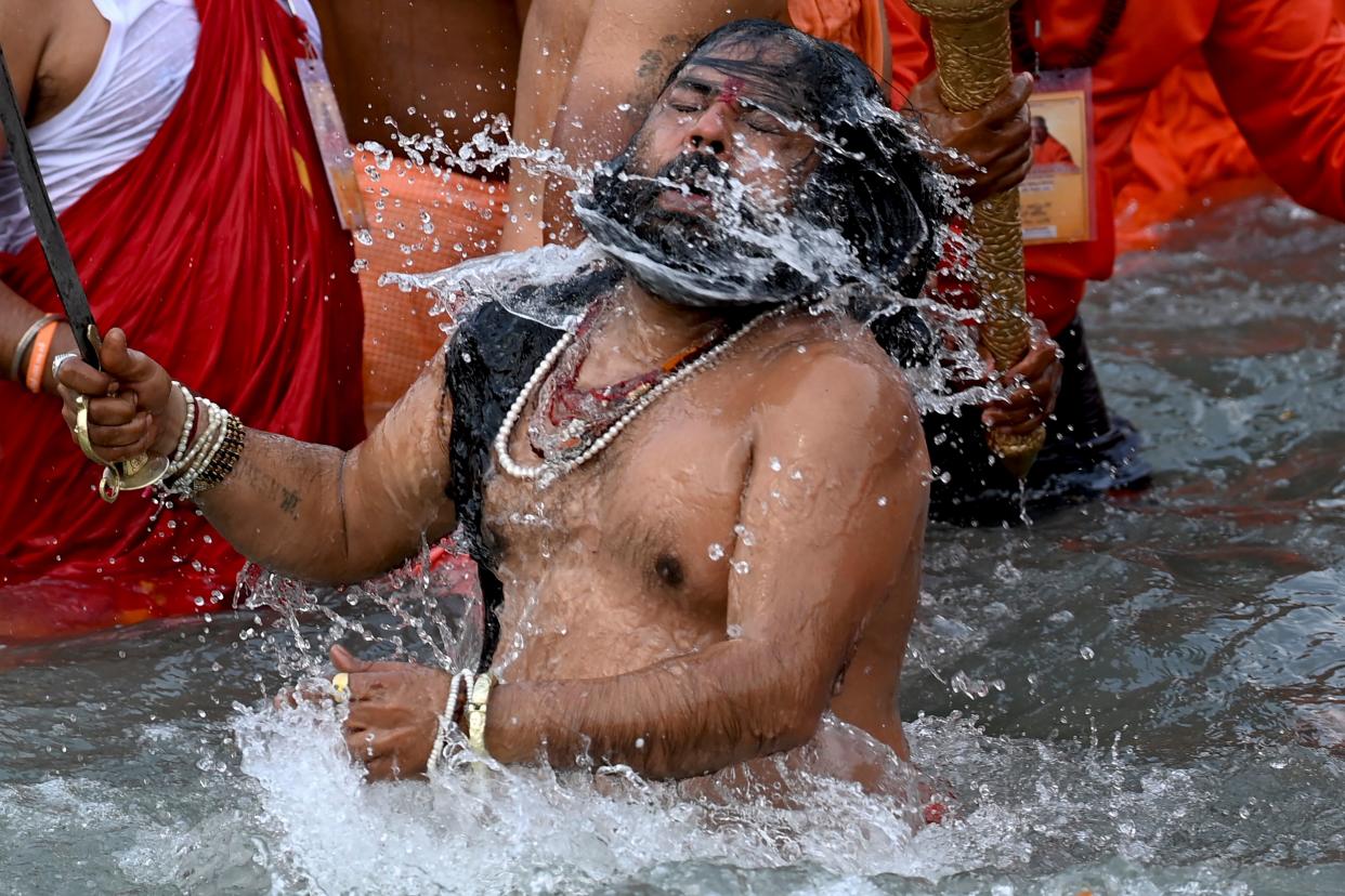 A Naga Sadhu (Hindu holy man) takes a holy dip in the waters of the Ganges River on the day of Shahi Snan (royal bath) during the ongoing religious Kumbh Mela festival, in Haridwar on April 12, 2021. (Photo by Money SHARMA / AFP) (Photo by MONEY SHARMA/AFP via Getty Images)