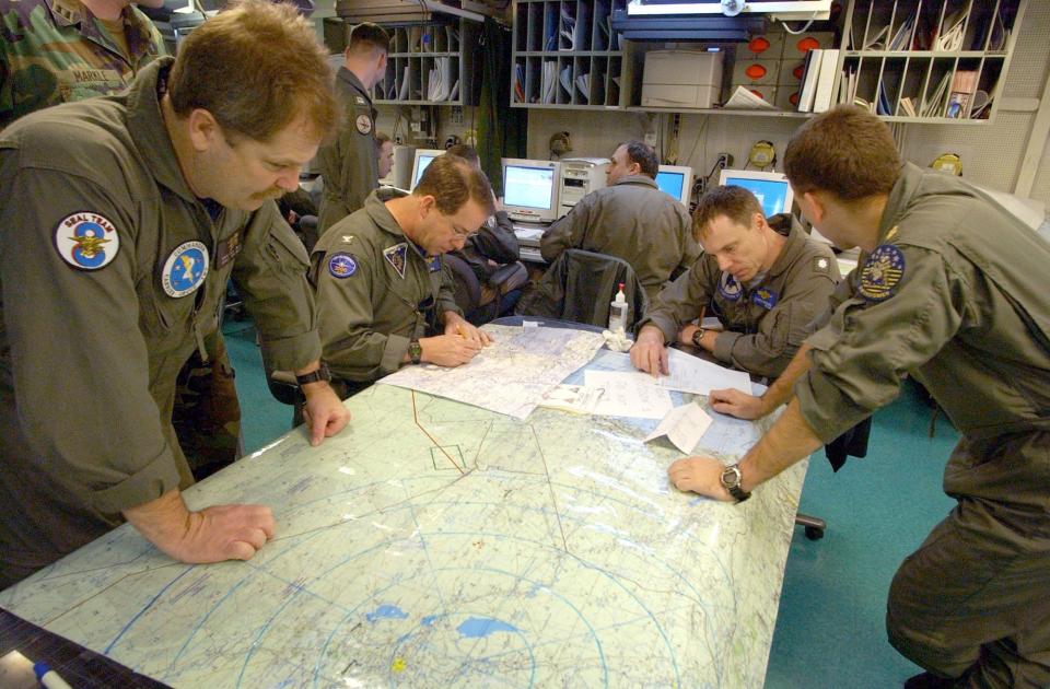 Navy SEAL looks at map on Truman carrier