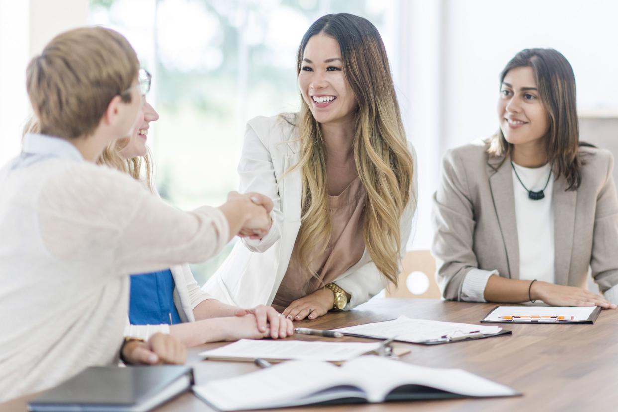 woman shaking hands with another woman at a meeting