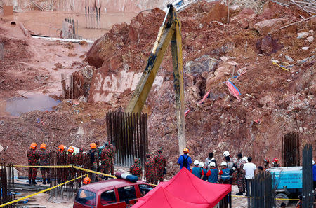 Rescue workers are seen at a construction site after it was hit by a landslide in Tanjung Bungah, a suburb of George Town, Penang, Malaysia October 21, 2017. REUTERS/Lai Seng Sin