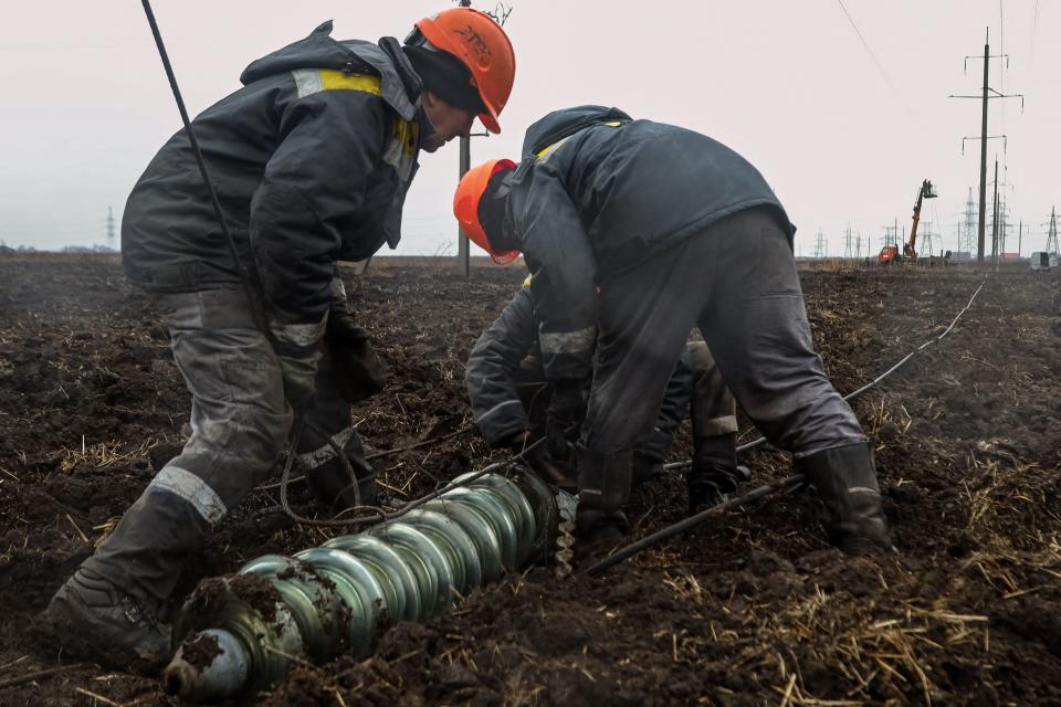 TOPSHOT - Arbetare reparerar högspänningsledningar som skars av nyligen missilangrepp nära Odessa den 7 december 2022, mitt i den ryska invasionen av Ukraina. – En ny störtflod av ryska strejker den 5 december lämnade flera ukrainska städer utan ström, inklusive den östra staden Sumy och den södra staden Mykolaiv, enligt tjänstemän. I Odessa, sa vattentjänstoperatören