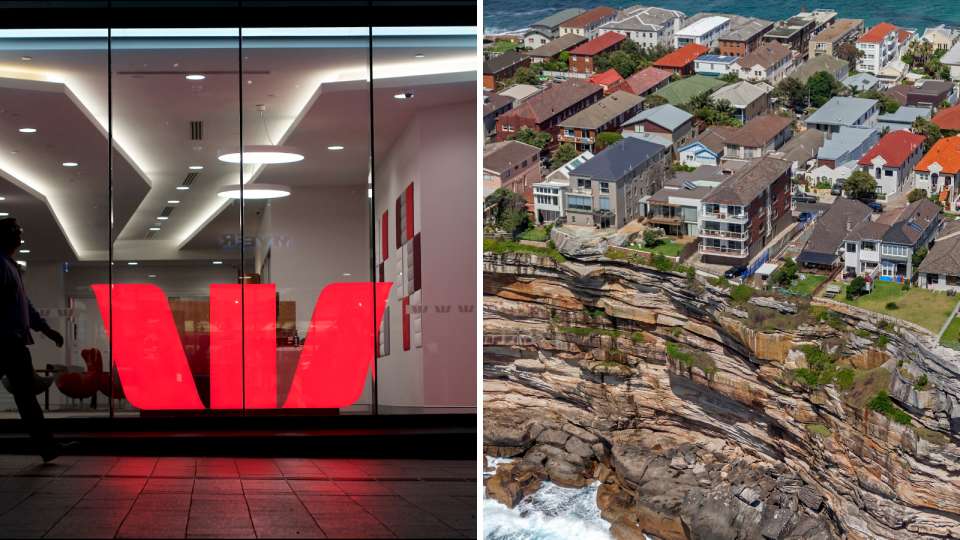 The Westpac logo in the window of a Westpac branch and houses on a cliff-edge in Sydney.