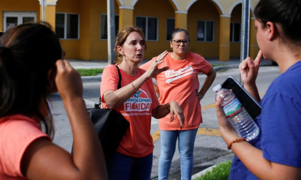 Immigration rights activists talk in Miami, during an event to hand out pamphlets as communities brace for a reported wave of Ice raids.