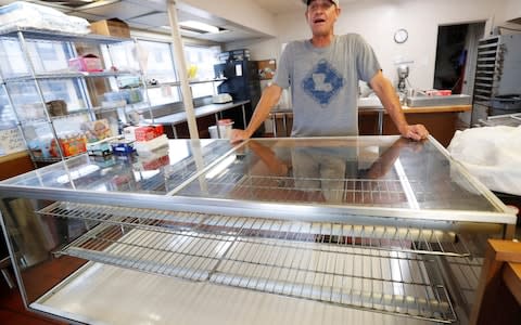 Donut shop owner Todd Hoffpauir still did a brisk trade despite the heavy rain - Credit: AP