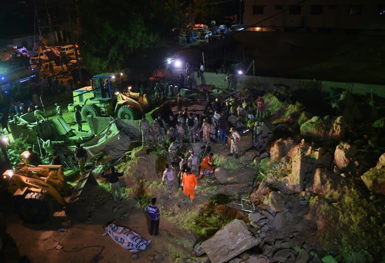 Pakistani soldiers and rescuers search for victims in the debris of a landslide in Karachi, on October 13, 2015