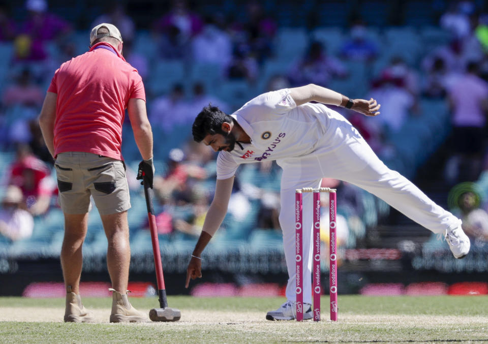 Indian bowler Jasprit Bumrah points to the pitch for a groundsman to work on during play on day three of the third cricket test between India and Australia at the Sydney Cricket Ground, Sydney, Australia, Saturday, Jan. 9, 2021. (AP Photo/Rick Rycroft)