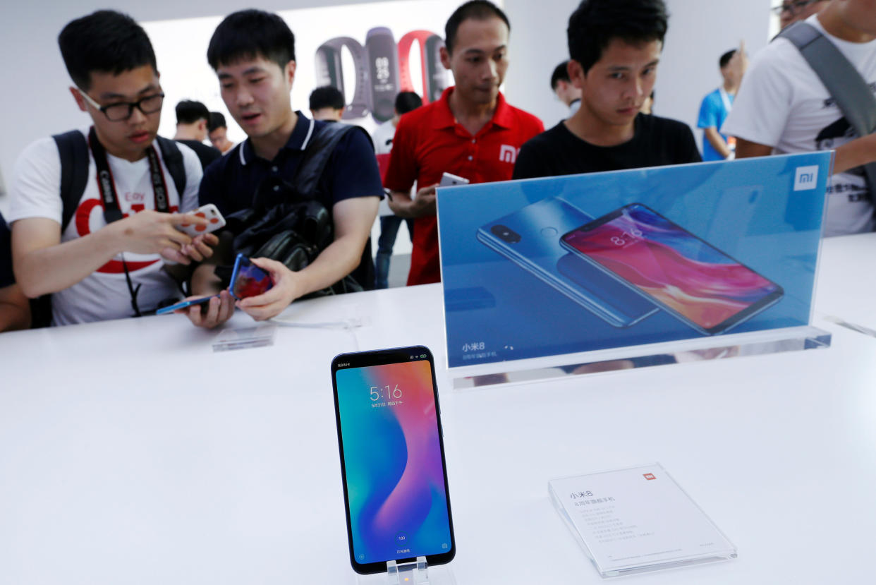 Fans check the new Xiaomi flagship Mi 8 during a product launch in Shenzhen, China on May 31, 2018. REUTERS/Bobby Yip