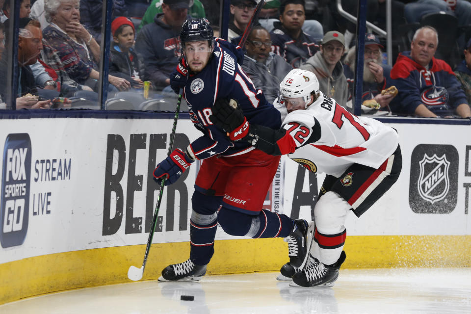 Columbus Blue Jackets' Pierre-Luc Dubois, left, looks for an open pass as Ottawa Senators' Thomas Chabot defends during the second period of an NHL hockey game Monday, Feb. 24, 2020, in Columbus, Ohio. (AP Photo/Jay LaPrete)