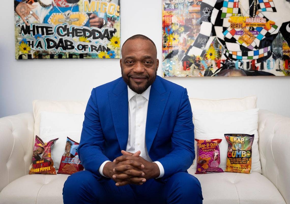 James Lindsay, CEO of Rap Snacks, poses on his office couch with some of the company’s chip bags on Monday, Feb. 26, 2024, at the company headquarters in downtown Miami. Rap Snacks features prominent rappers and hip-hop artists on its snack bags.