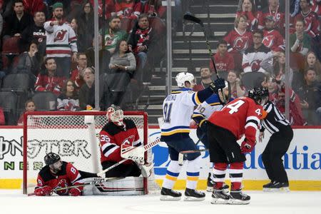 Mar 30, 2019; Newark, NJ, USA; New Jersey Devils goaltender Cory Schneider (35) and defenseman Will Butcher (8) and left wing Miles Wood (44) react after a goal scored by St. Louis Blues defenseman Vince Dunn, not pictured, while St. Louis Blues center Ryan O'Reilly (90) and right wing Vladimir Tarasenko (91) celebrate during overtime at Prudential Center. Mandatory Credit: Vincent Carchietta-USA TODAY Sports