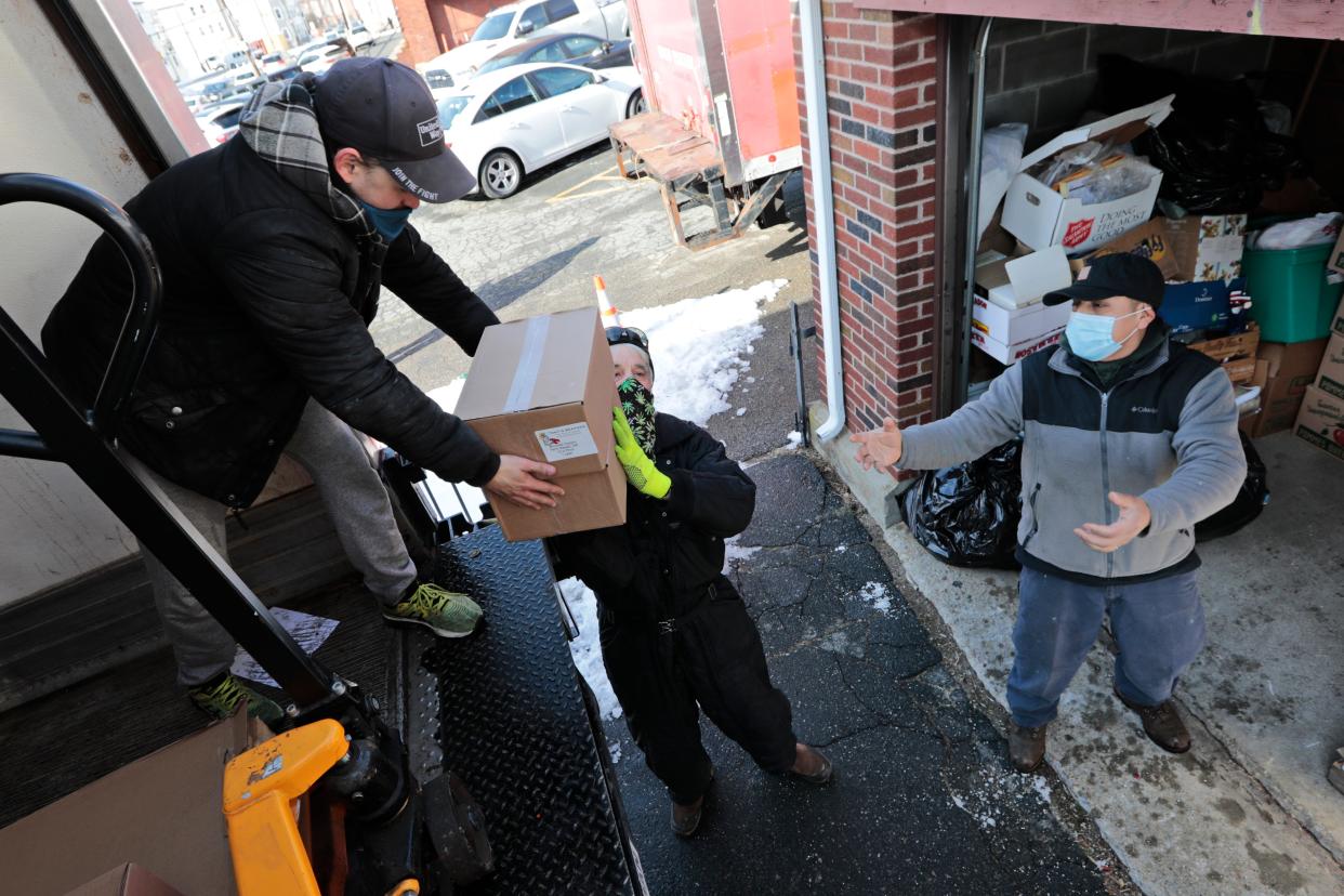 Ryan Miller of the United Way hands boxes to volunteers handing out food at the St. Anthony of Padua food pantry in New Bedford.