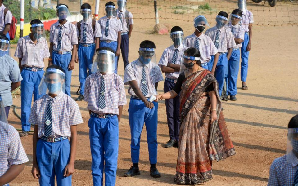 Students wearing facemasks and face-shields attend an assembly after their school reopened for the 9th and 10th grades following nearly ten months closure due to the pandemic - NOAH SEELAM /AFP