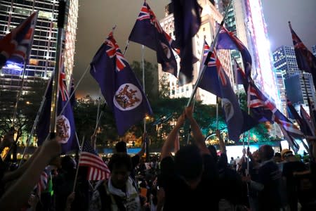 Anti-extradition bill protesters hold colonial flags of Hong Kong during a rally calling on the British and U.S. governments to monitor the implementation of "one country two systems" principal, in Hong Kong