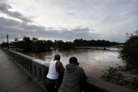 Gerald Generette, derecha, y Maurice Millen observan el río Cape Fear mientras sus niveles continúan aumentando a causa del huracán Florence, en Fayetteville, Carolina del Norte, el lunes 17 de septiembre de 2018. (AP Foto/David Goldman)